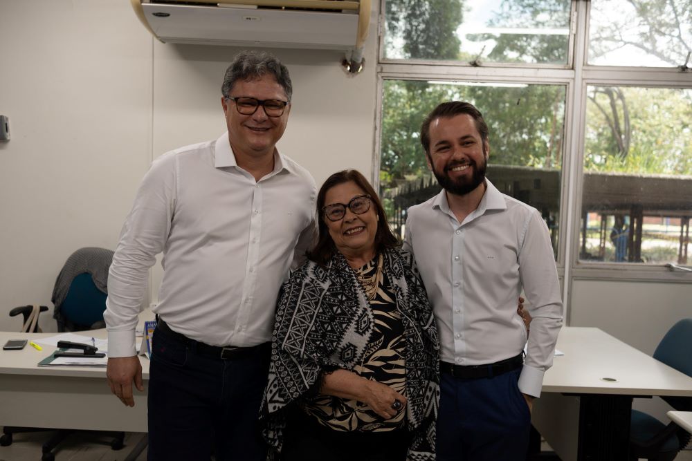 Servidora do DETRAN-PE ladeada pelo presidente e secretário de mobilidade do Estado de PE.