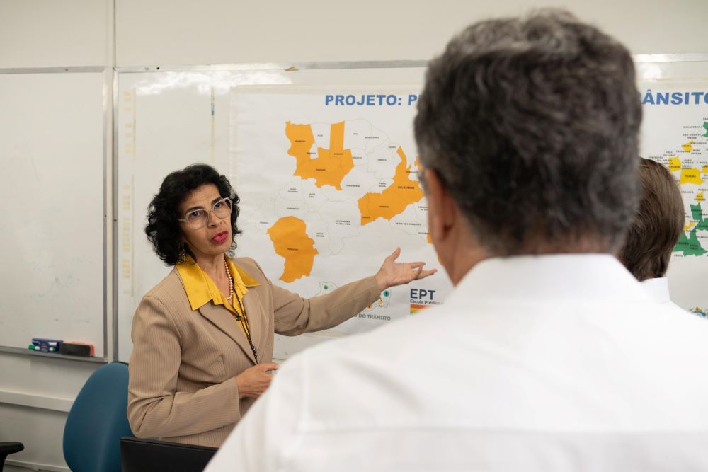 Servidora do DETRAN-PE mostrando as áreas de atuação do órgão.