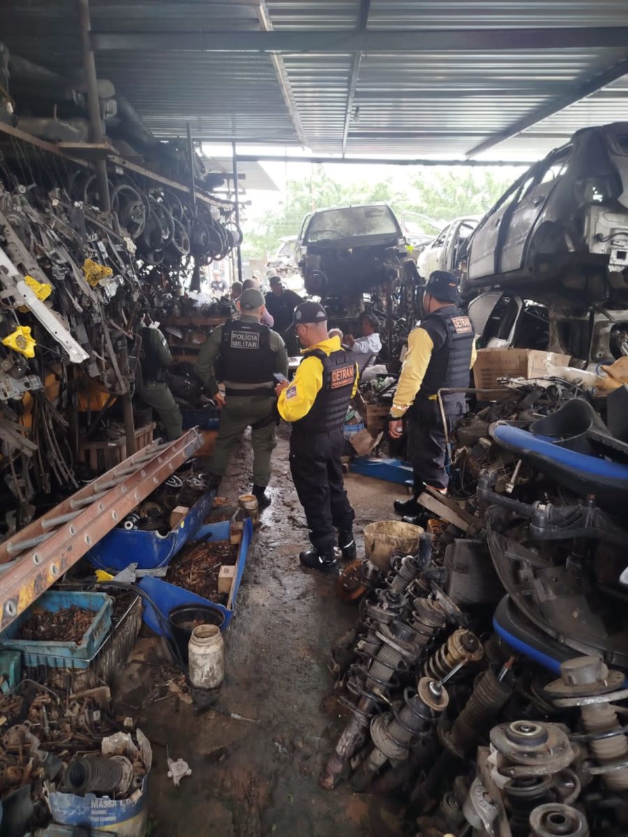 Policiais civis e agentes de trânsito do DETRAN-PE anotando irregularidades em depósito de peças e carros usados