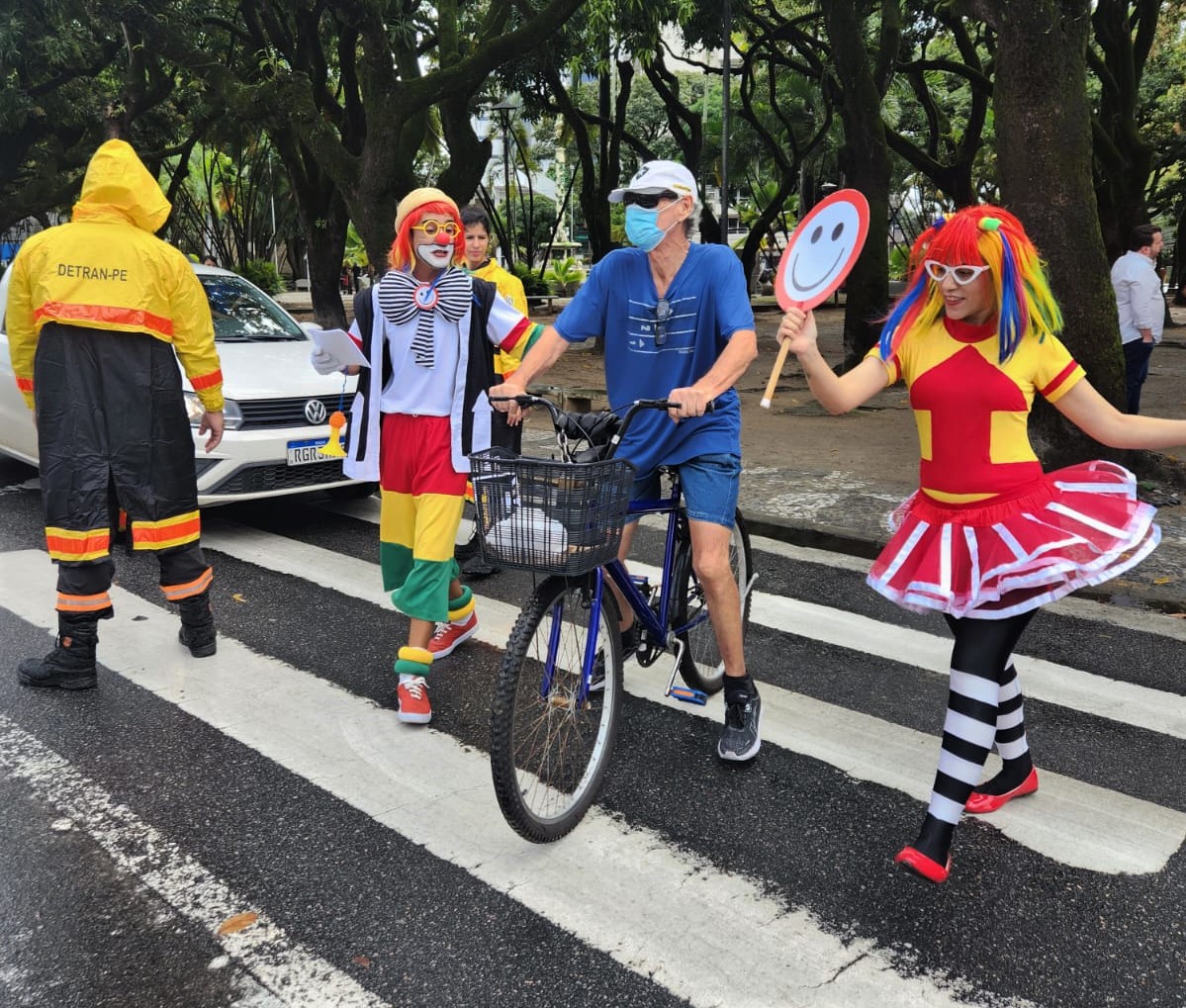 Fotografia colorida mostrando a Turma do Fom-Fom atuando em faixa de pedestre
