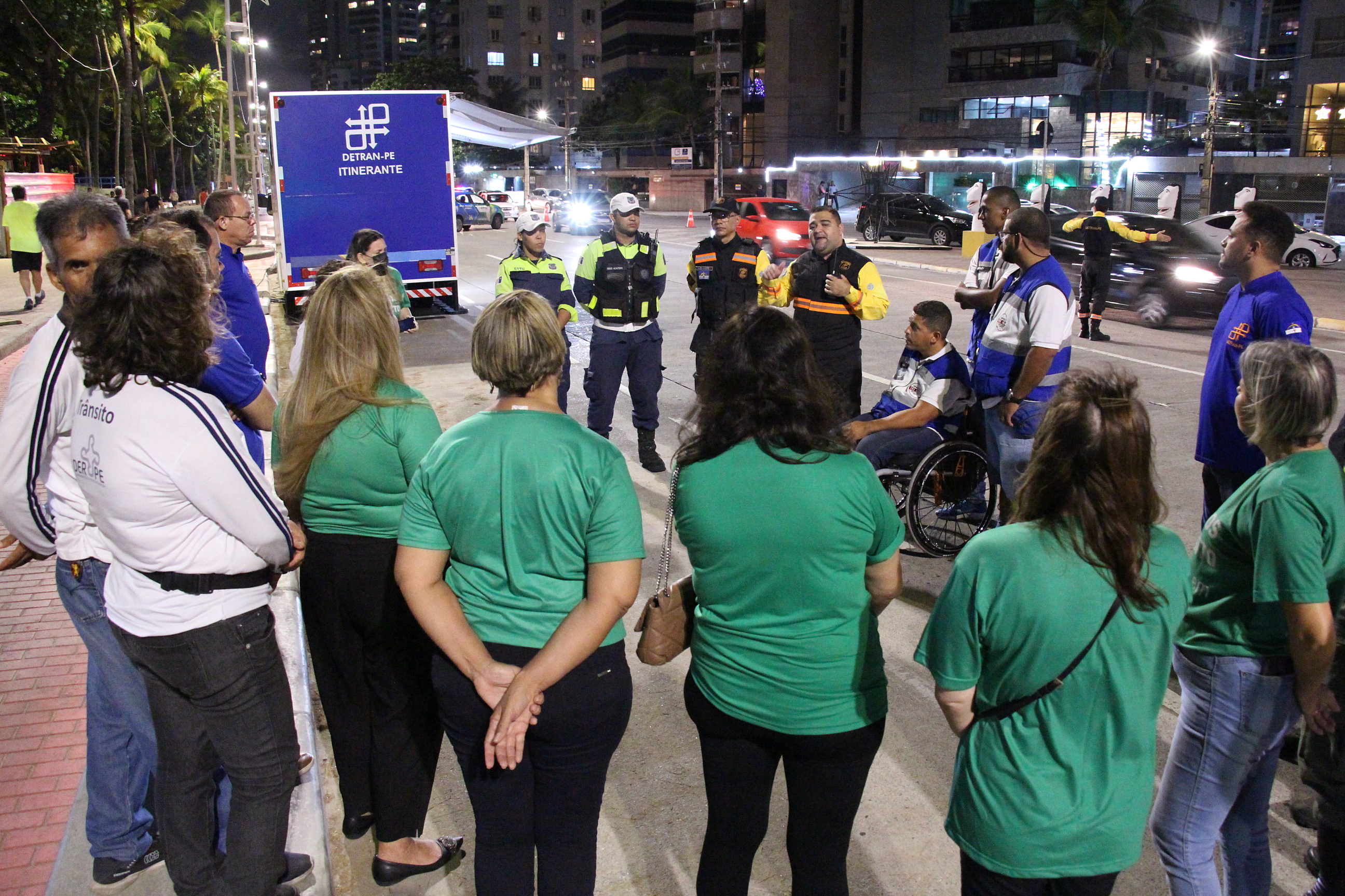 Na foto, agente de trânsito e educadores de trânsito do DETRAN-PE; agentes de trânsito da CTTU, Operação Lei Seca e DER; além de psicólogas de tráfego da Abrapsit, reunidos em círculo, antes do início da blitz sobre educação de trânsito, alinhando os detalhes da operação. 
