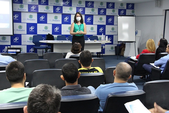 Examinadores prestando atenção a palestra ministrada no auditório do orgão
