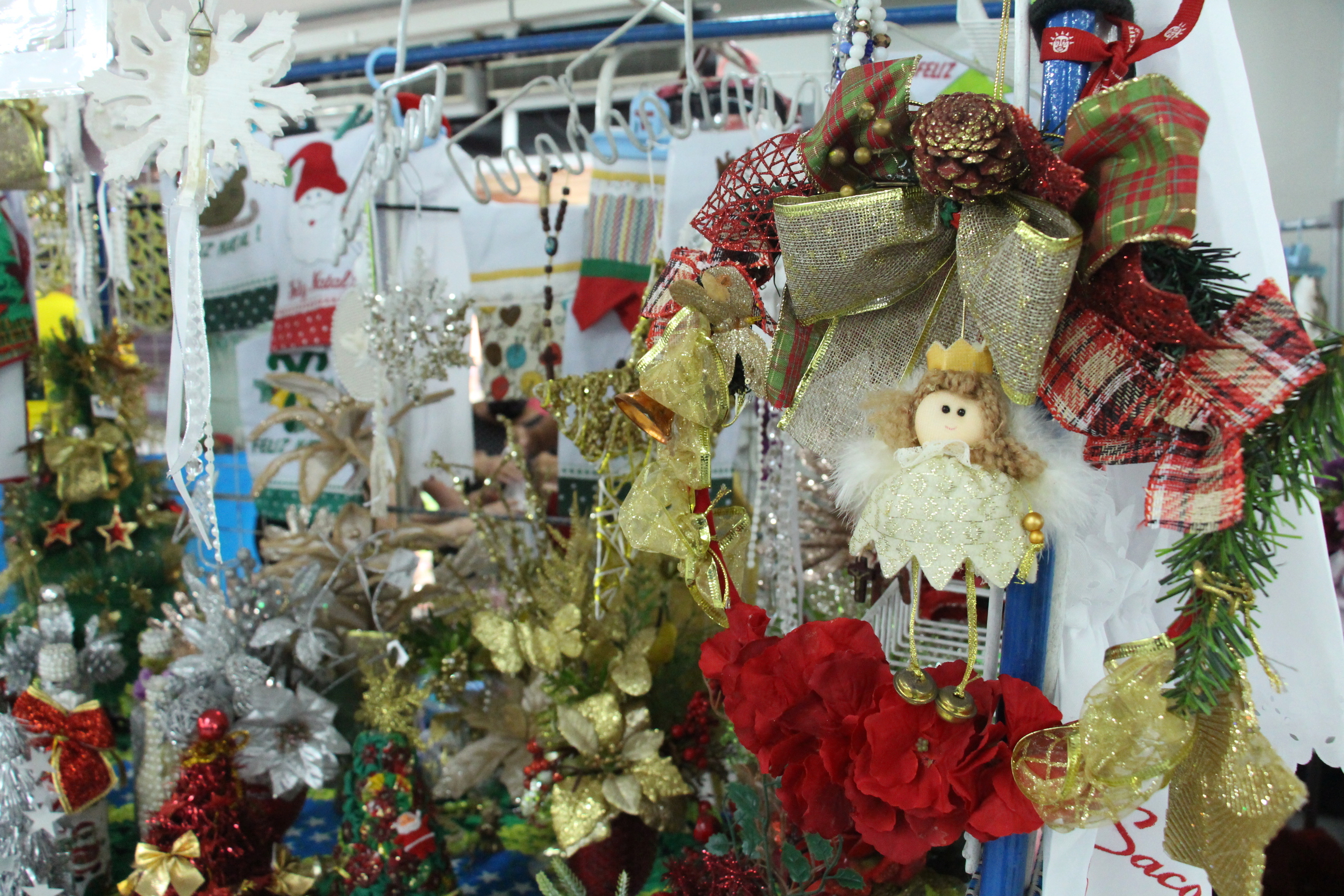 Em foto colorida duas compradoras do sexo feminino estão diante de um estande observando os produtos