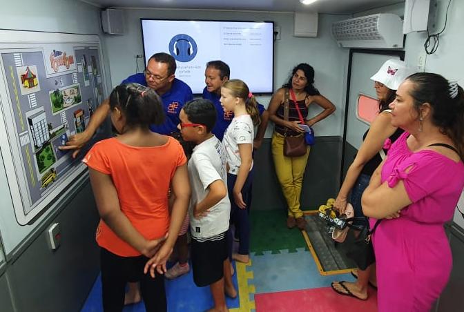 Na foto, educador de educação de trânsito do DETRAN-PE mostrando atividade lúdica sobre os cuidados no trânsito às crianças. 