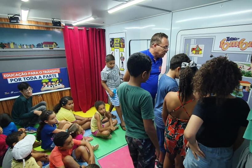 Na foto, educador de educação de trânsito do DETRAN-PE mostrando atividade lúdica sobre os cuidados no trânsito às crianças. 