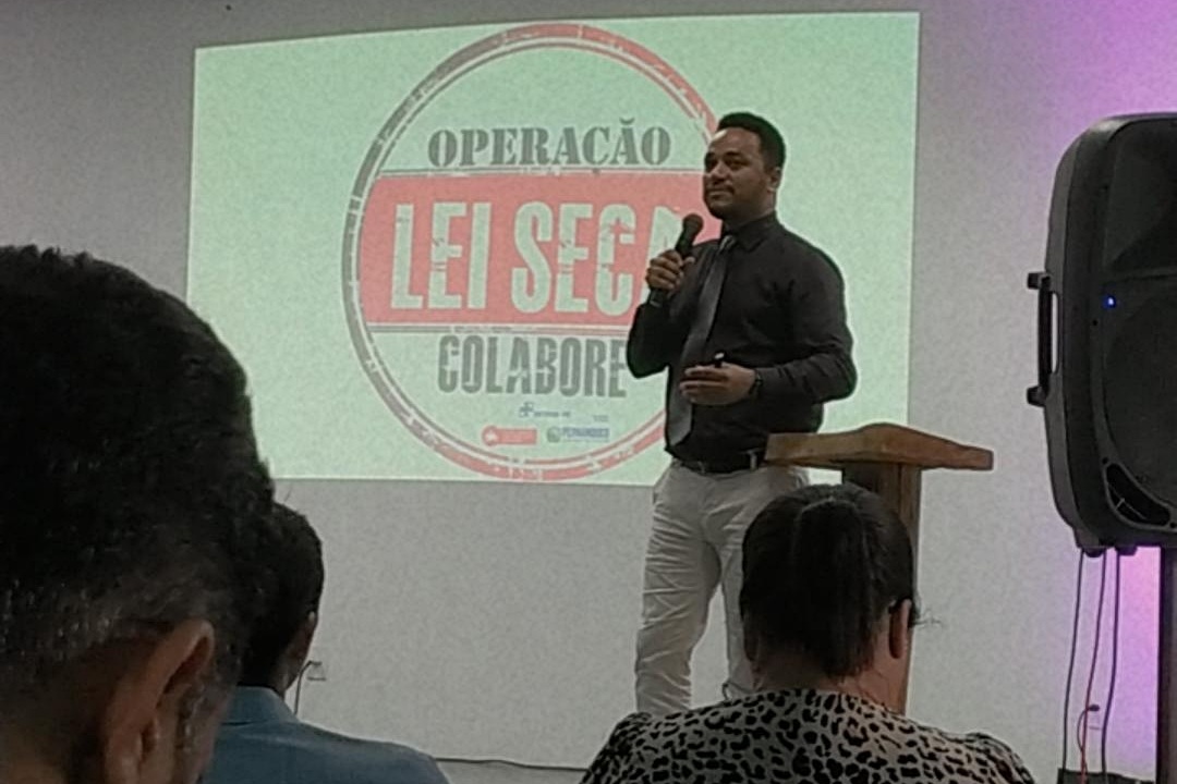 O gerente da Escola Pública de Trânsito (EPT) do DETRAN-PE, Ivson Correia, palestrando no I Encontro sobre “A Importância do Pleno Funcionamento de um Órgão Executivo de Trânsito”, promovido pela Prefeitura de Igarassu. Ao fundo, a logo da Lei Seca. 