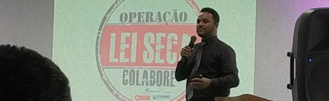 O gerente da Escola Pública de Trânsito (EPT) do DETRAN-PE, Ivson Correia, palestrando no I Encontro sobre “A Importância do Pleno Funcionamento de um Órgão Executivo de Trânsito”, promovido pela Prefeitura de Igarassu. Ao fundo, a logo da Lei Seca. 