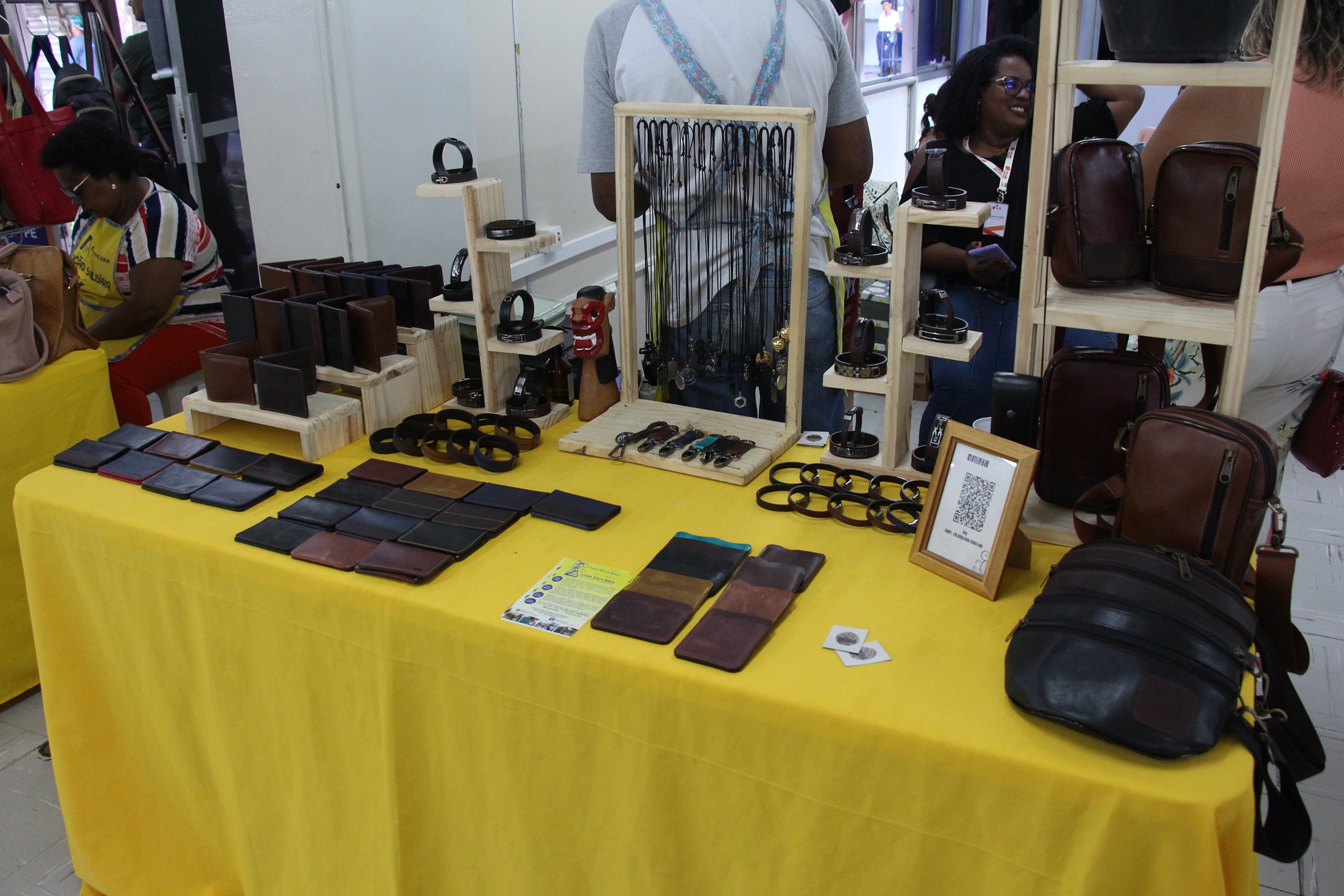Na foto, uma barraca com exposição de carteiras, bolsas e pulseiras em couro, além de colares personalizados.