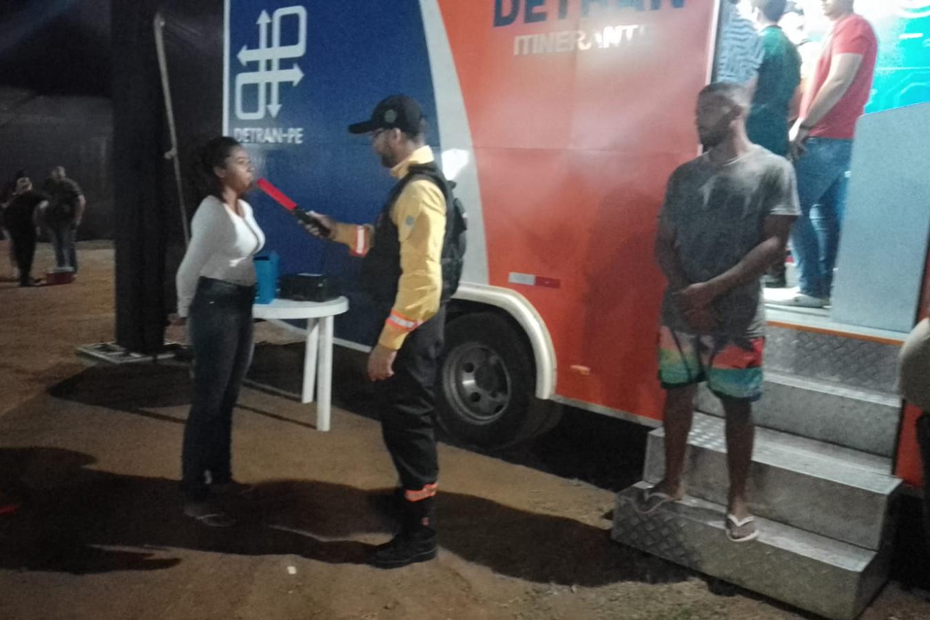 Agente de trânsito realizando procedimento educativo em frente a unidade do Detran Itinerante.