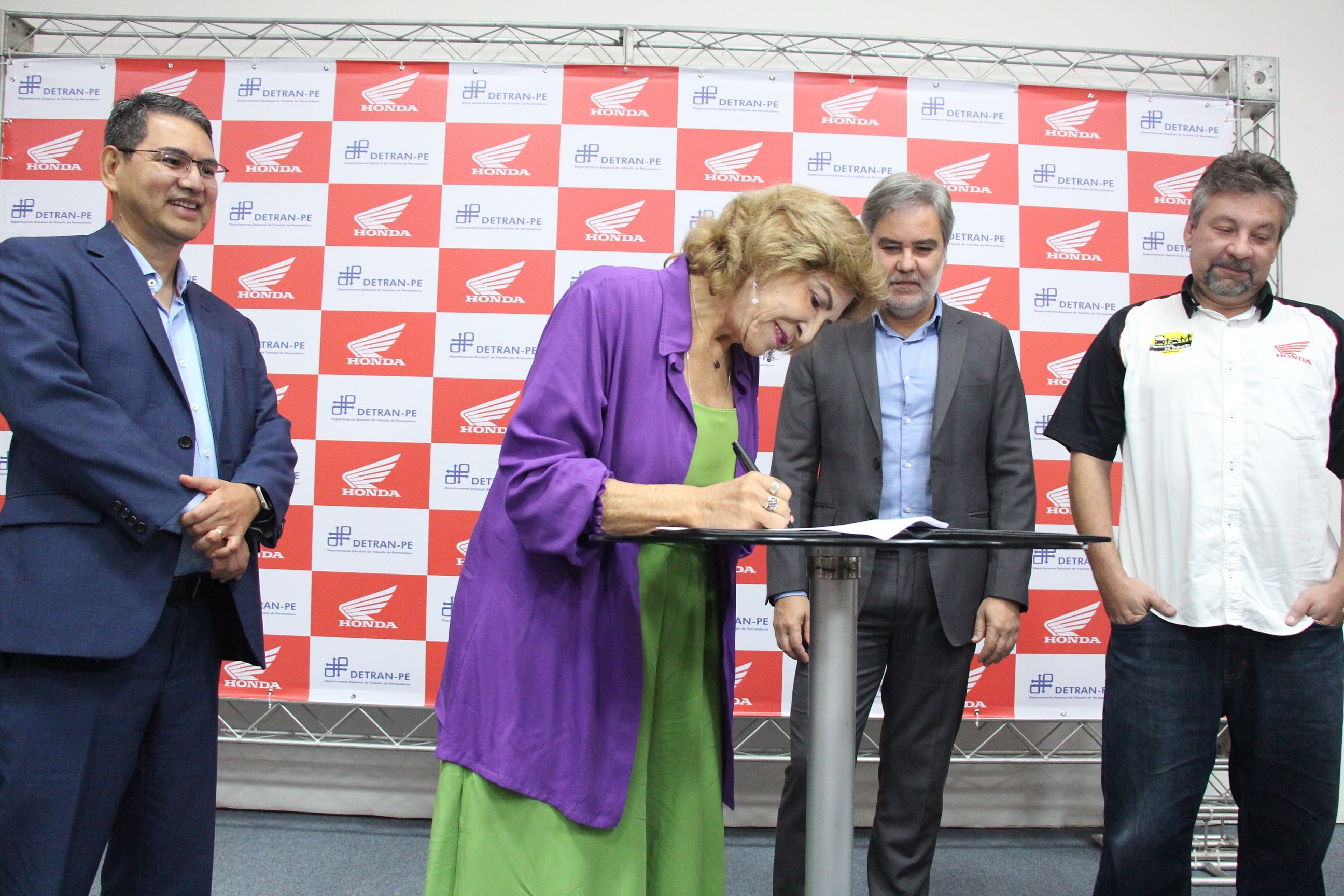 Coordenadora de Educação de Trânsito, Imprensa e Publicidade Institucional do DETRAN-PE, Jô Lima, assina Termo de Cooperação Técnica do DETRAN-PE com a Honda. Ao seu lado, estão Diretor Presidente do Departamento Estadual de Trânsito - DETRAN-PE, Gustavo Carneiro Leão; o Diretor de Relações Institucionais da Moto Honda da Amazônia, Marcos Bento; e o Gerente das Unidades dos Centros Educacionais de Trânsito da Honda Brasil, Leonardo Donato.
