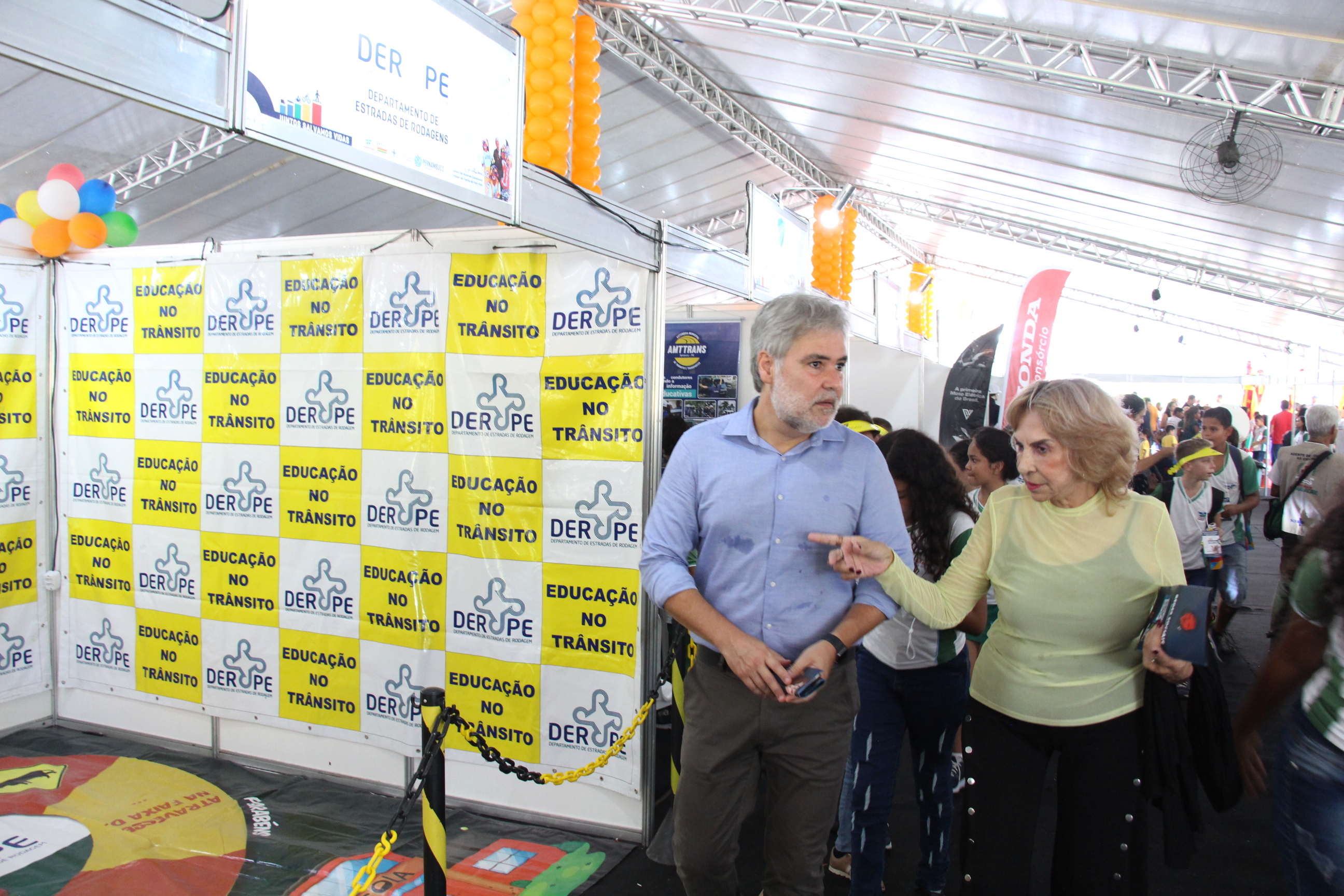 Na foto, Na foto,  o Diretor Presidente do DETRAN-PE, Gustavo Carneiro Leão, acompanhado da  Coordenadora de Educação de Trânsito, Imprensa e Publicidade Institucional do DETRAN-PE, Jô Lima, circulando na 20º Feira de Educação para o Trânsito de Pernambuco, que acontece na Praça de Eventos de Camaragibe.
