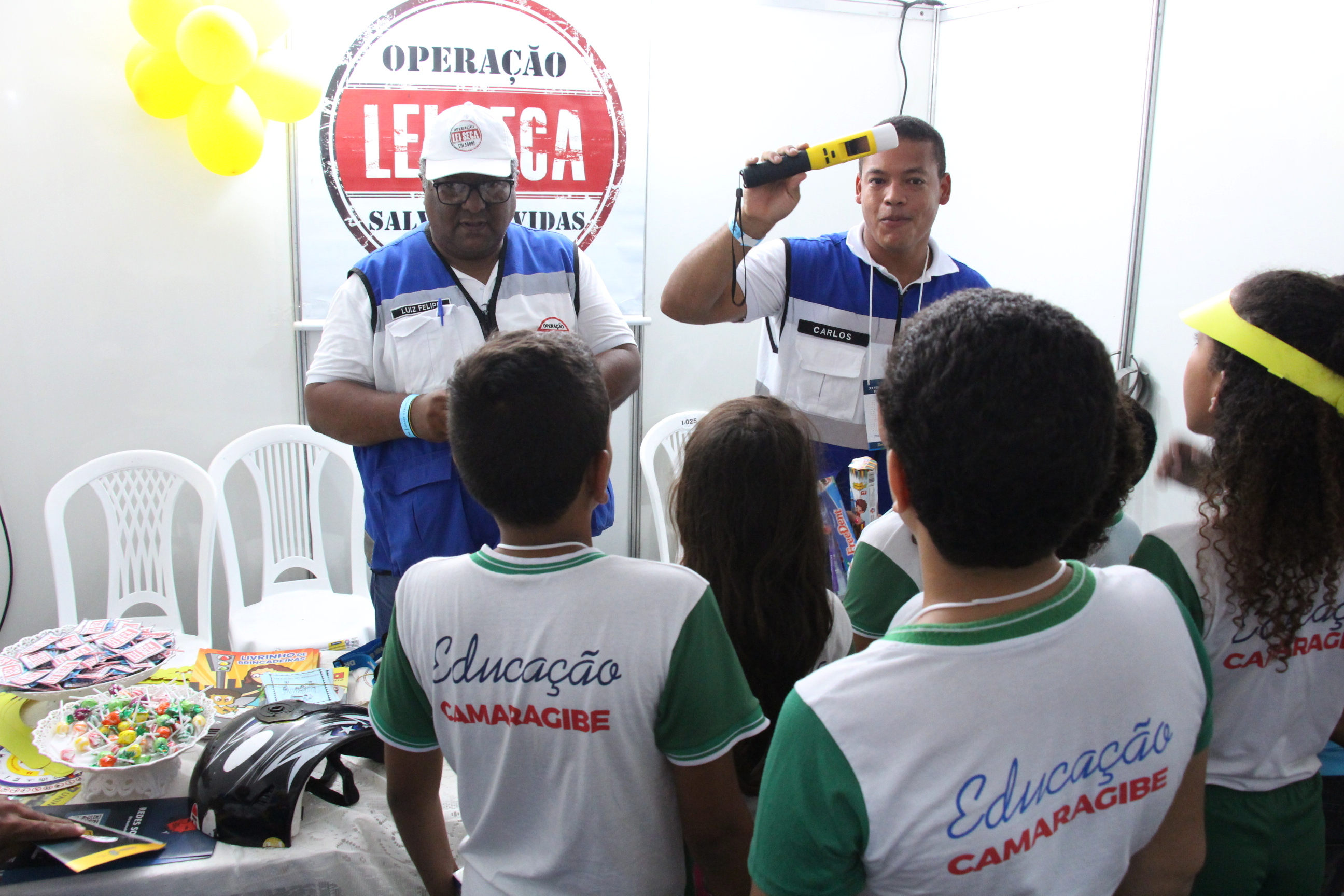 Na foto, educadores da Operação Lei Seca mostrando as crianças os perigos da mistura fatal de álcool e direção na 20º Feira de Educação para o Trânsito de Pernambuco, que acontece na Praça de Eventos de Camaragibe.
