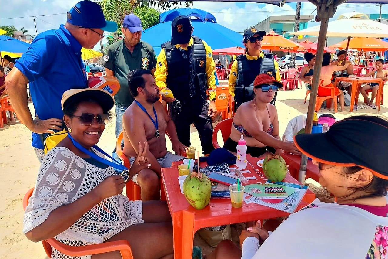 Na foto, família sendo abordada por Educador de Trânsito e Agente de Trânsito do DETRAN-PE. No local, foi utilizado o bafômetro de forma educado e distribuído medalha de amigo da vez para quem não bebeu. 