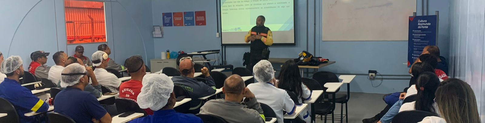 Foto colorida de agente de trânsito ministrando palestra