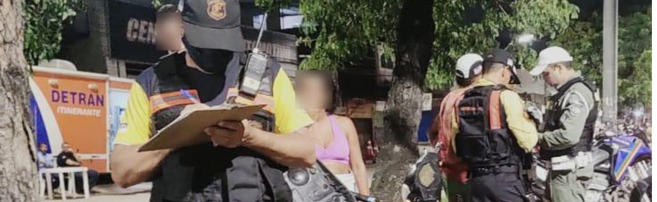 Na foto, agente de trânsito do DETRAN-PE e policiais da Polícia Militar de Pernambuco, realizando abordagem em motocicletas. Ao fundo, o caminhão do DETRAN Itinerante.