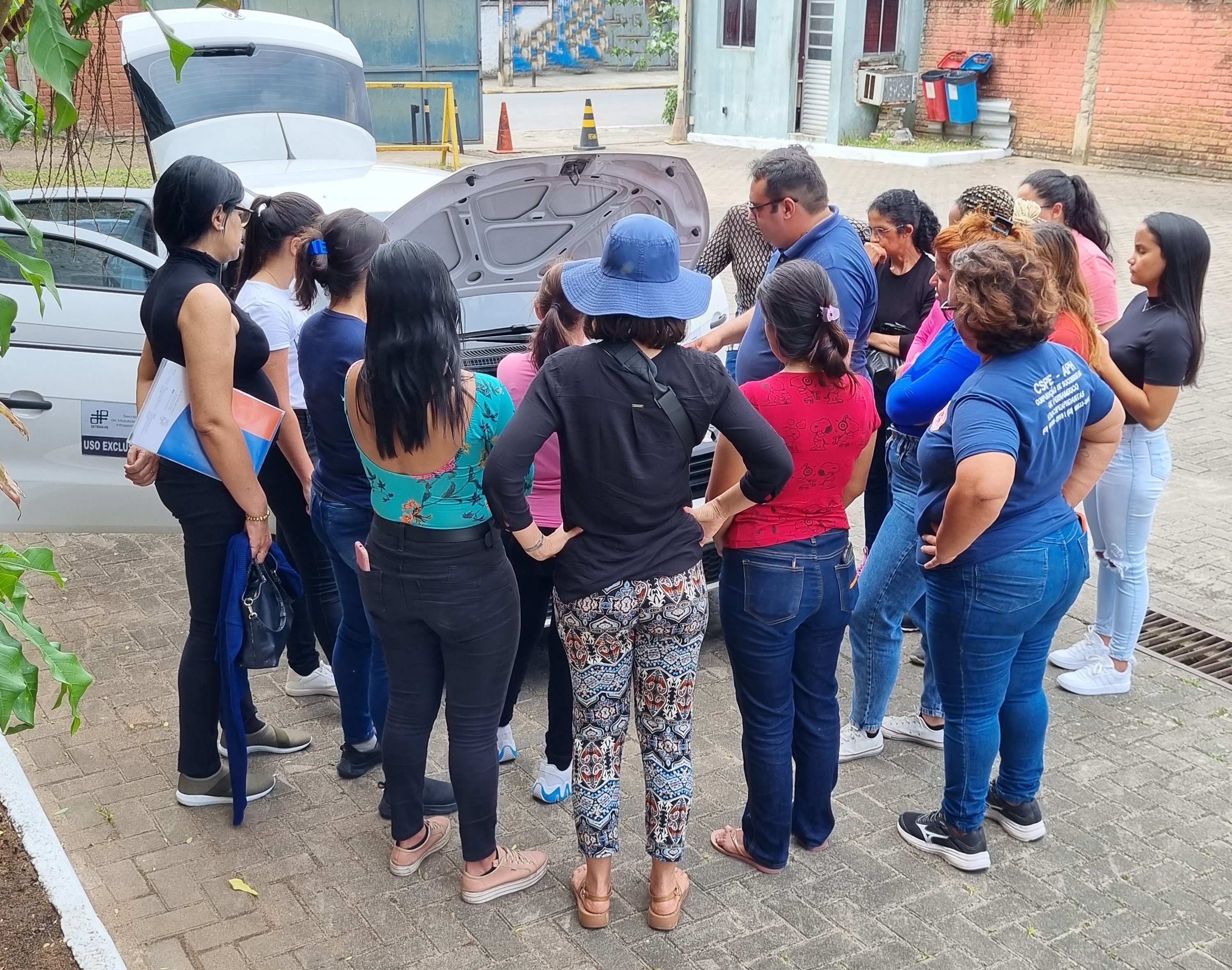 Foto colorida de mulheres observando motor de veículo