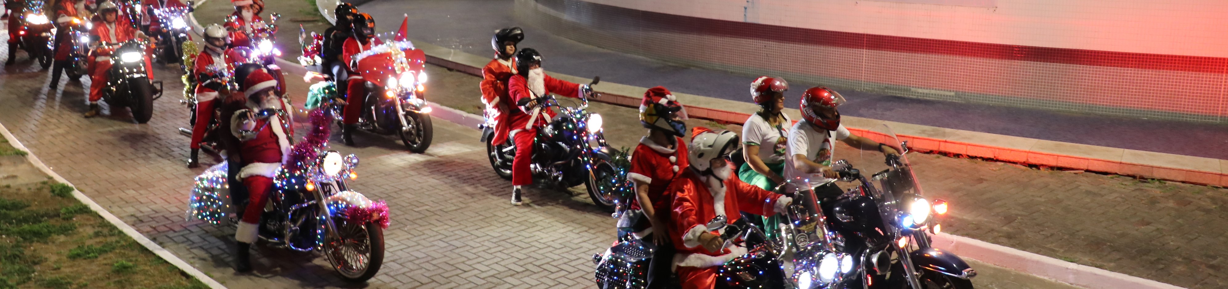 Foto colorida dos motociclistas vestidos de Papai Noel