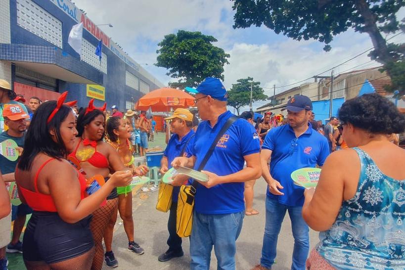 Na foto, educadores de trânsito do DETRAN-PE distribuindo leques abanadores nas prévias carnavalescas. 