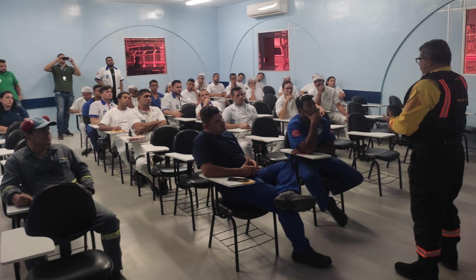 Foto colorida de agente de trânsito ministrando palestra