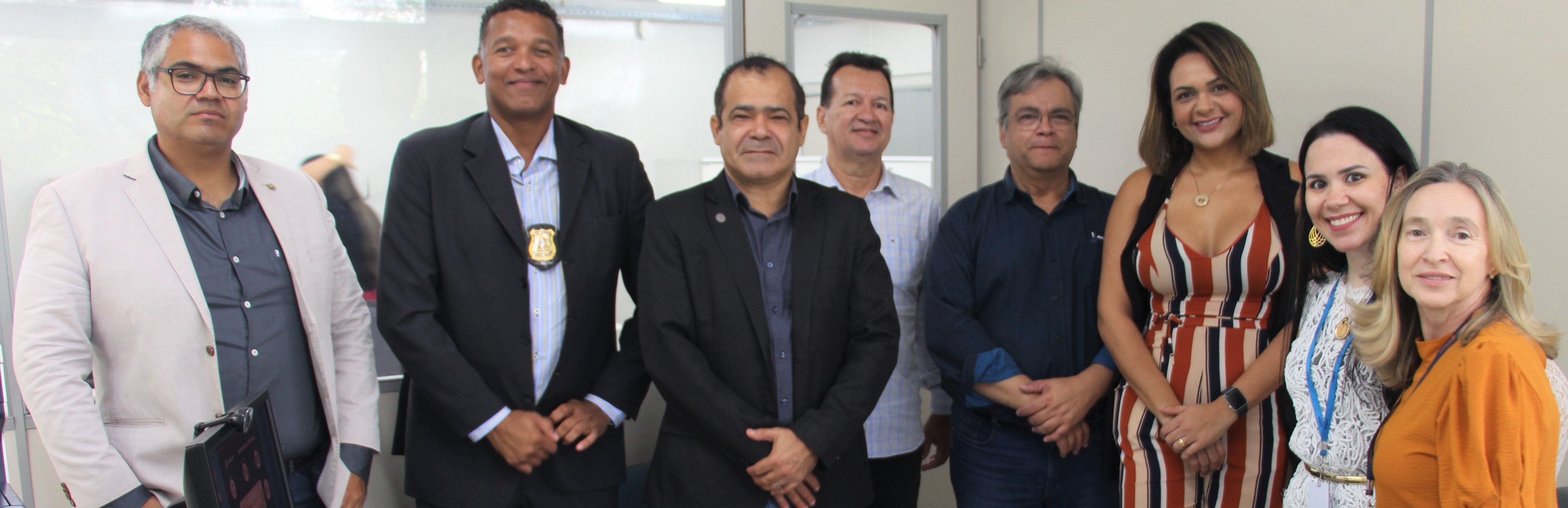 Foto colorida com participantes da reunião de pé lado a lado