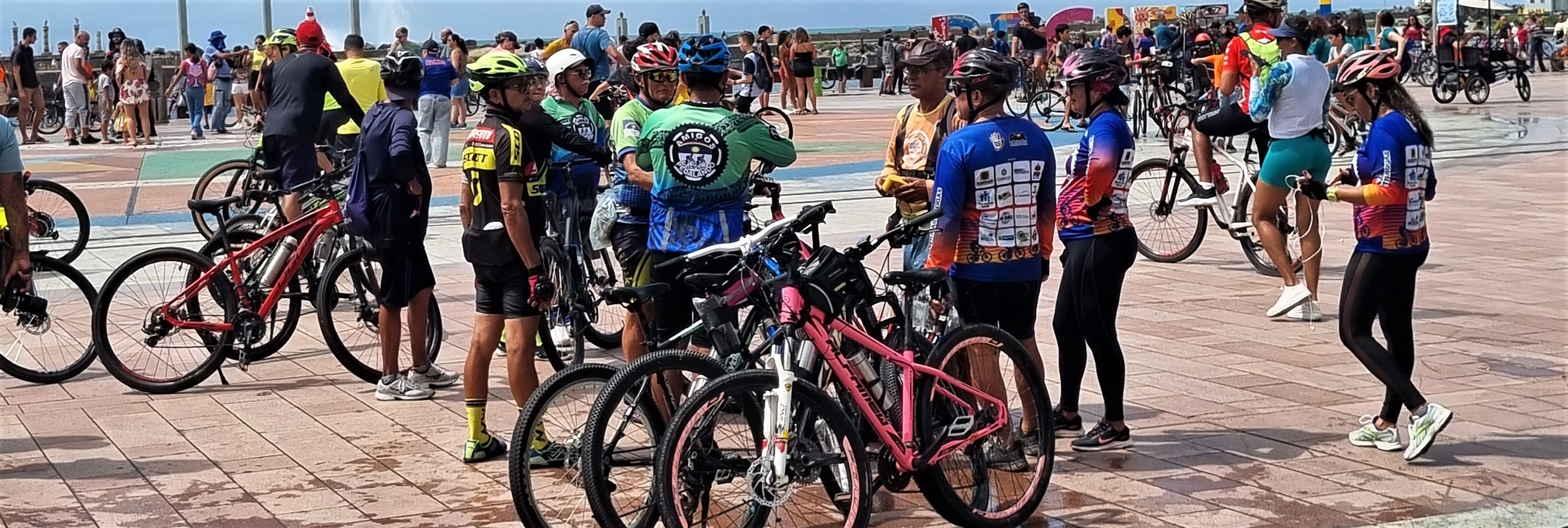 Imagens de ciclistas parados na praça do Marco Zero de Recife.