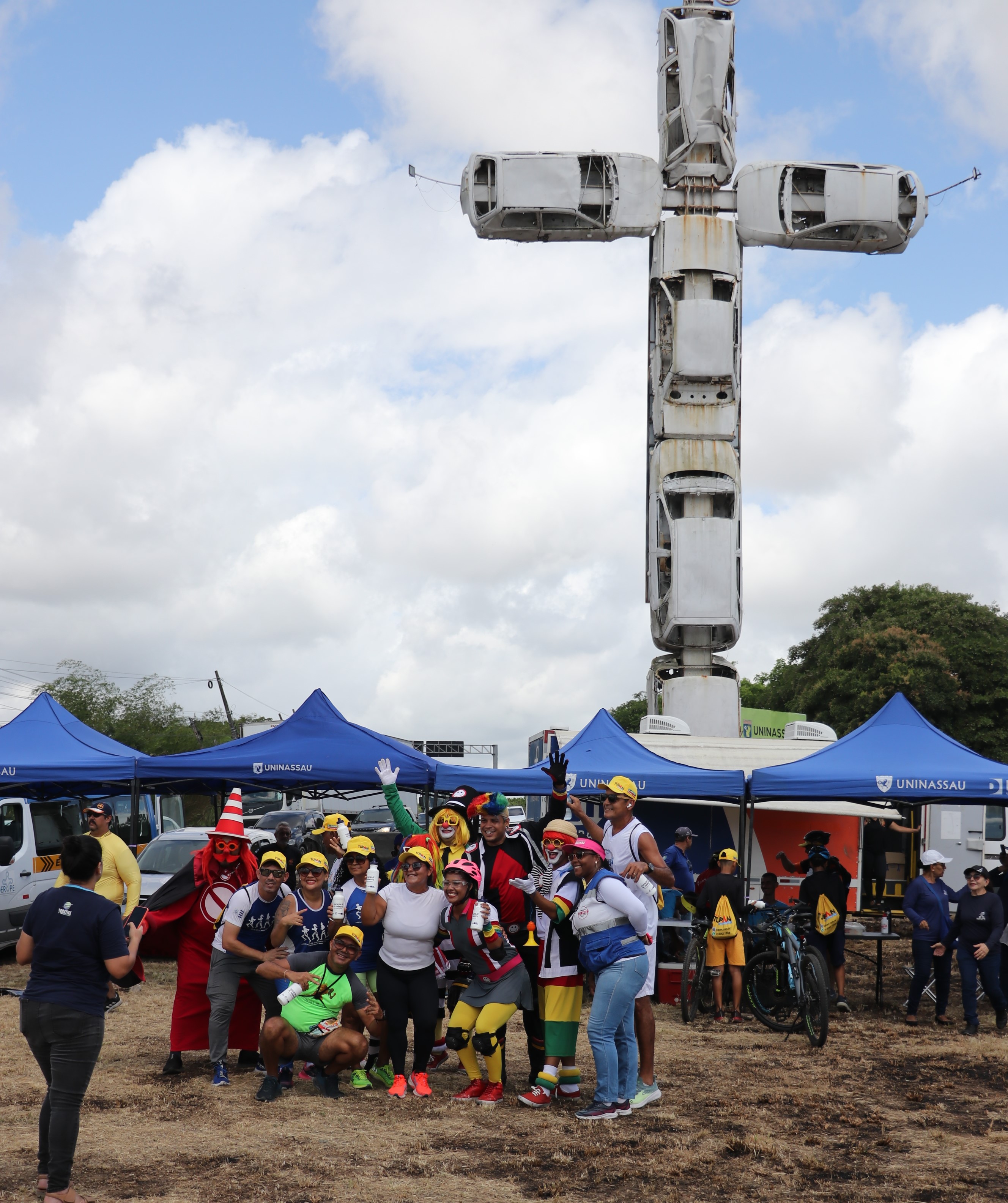 Foto das equipes com a Turma do Fom-Fom no crucifixo automotivo