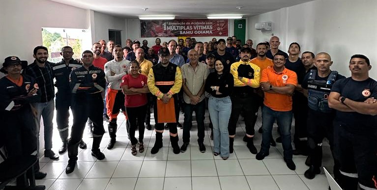 Fotografia colorida com todos os participantes do curso de pé