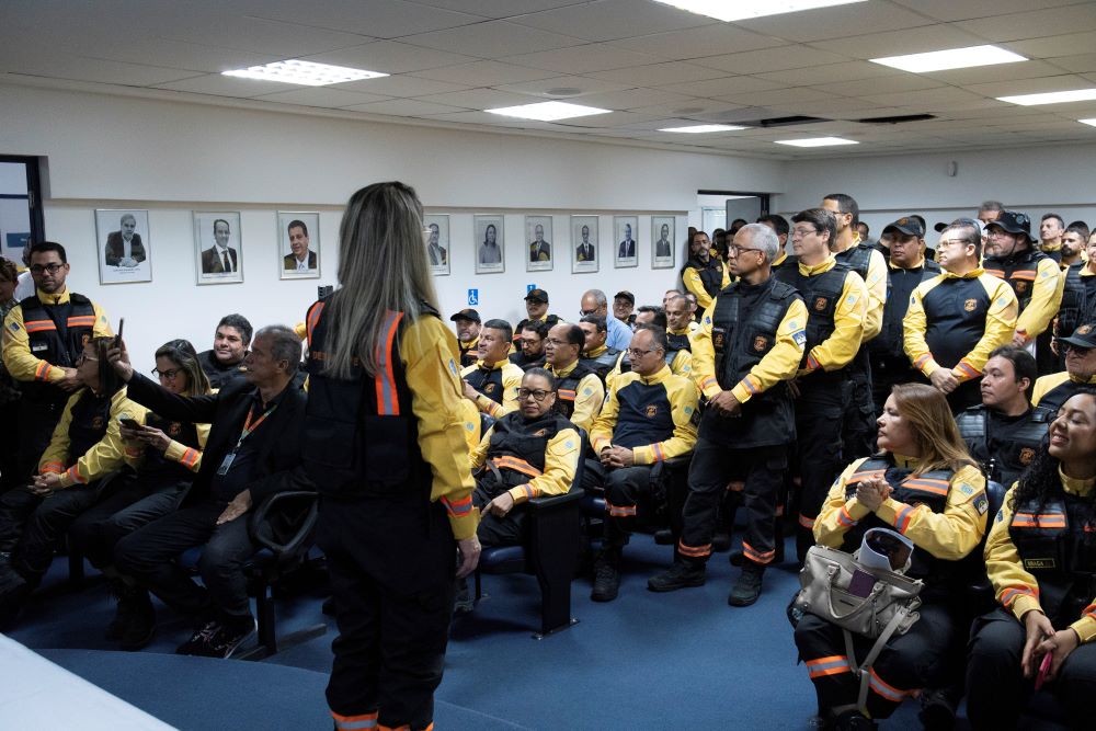 Emilia Florêncio de frente para um auditório lotado com diversos agentes de fiscalização do DETRAN-PE.