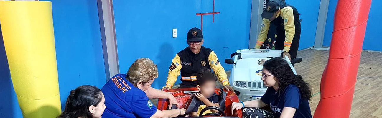 Agentes de trânsito auxiliando criança em ação de educação de trânsito