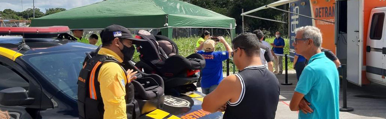 Agente do Detran instruindo sobre o uso da cadeirinha