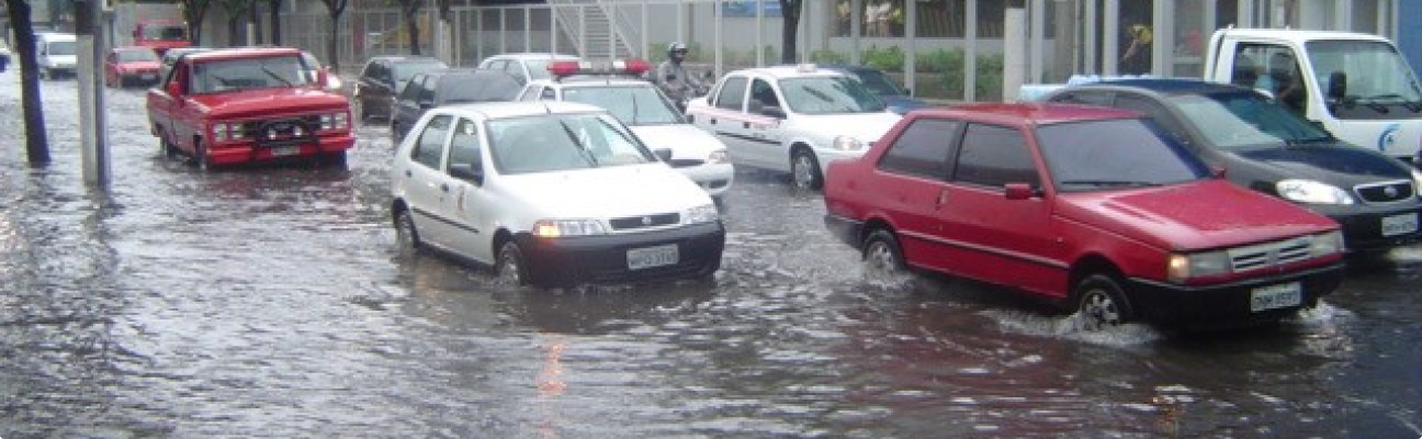 foto de carros passando em rua alagada