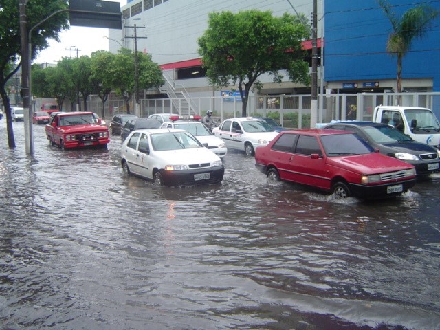 foto de carros passando em rua alagada