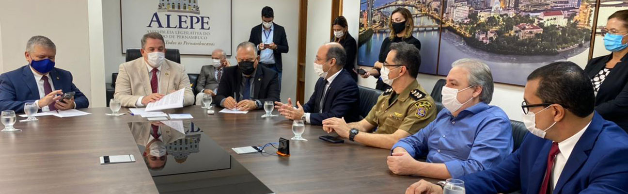 Foto de pessoas sentadas em uma sala no momento  em que a instrução normativa é assinada