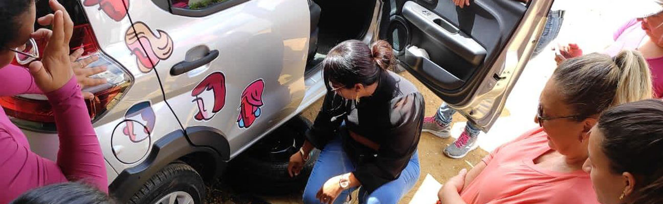 foto de mulheres ao redor de um carro recendo instruções do curso prático de mecânica de automóveis para mulheres