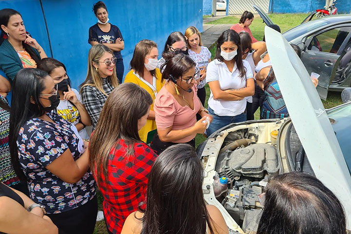 Foto de mulheres ao redor de um carro realizando o curso